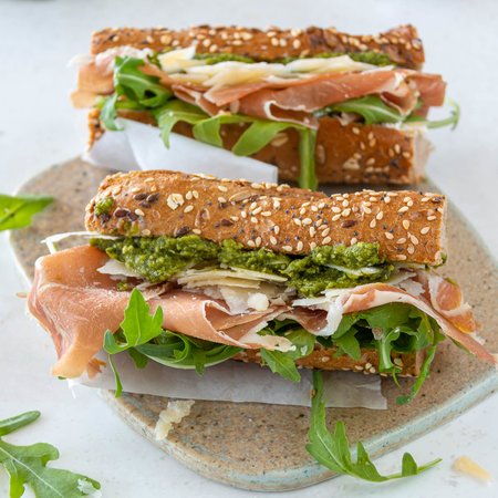 Halbes Körnerbaguette mit Parmaschinken, Parmesan, Basilikumpesto und Rucola